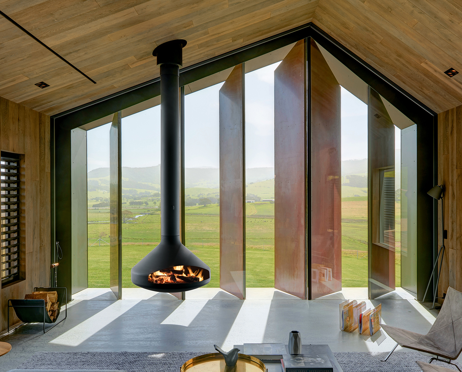 Focus Ergofocus suspended pivoting fireplace with angular folded steel hood, a smaller sibling to the Gyrofocus
