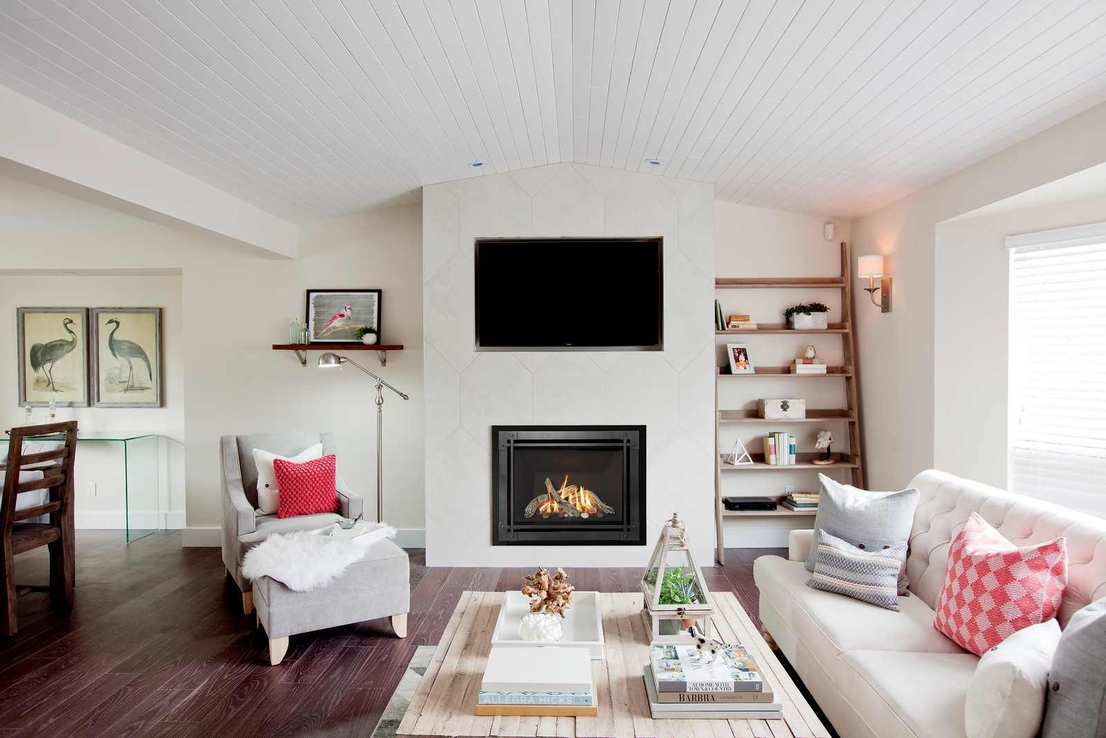 Valor H5 radiant gas fireplace with a wall-mounted television above, set into a pale tile chimney breast in a bright living room with a vaulted plank ceiling