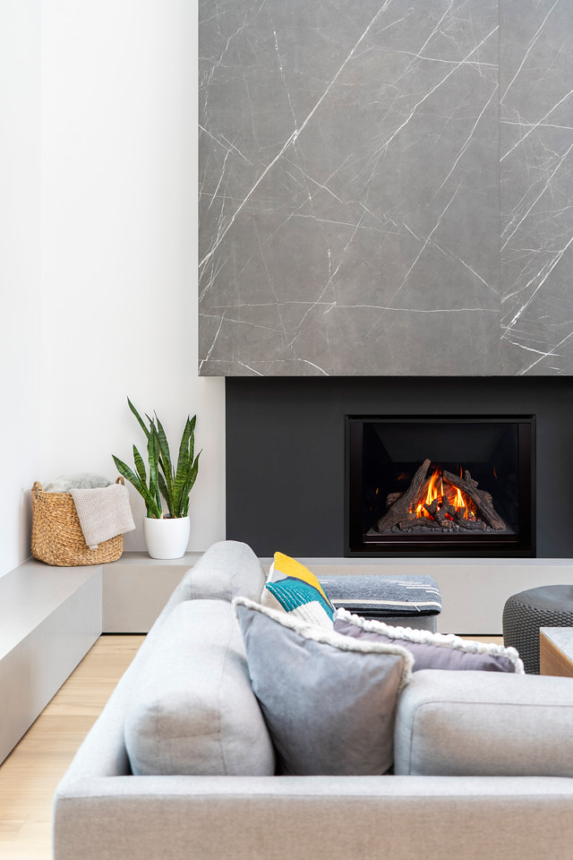 Valor H6 large-format radiant gas fireplace beneath a grey marble surround in a contemporary living room