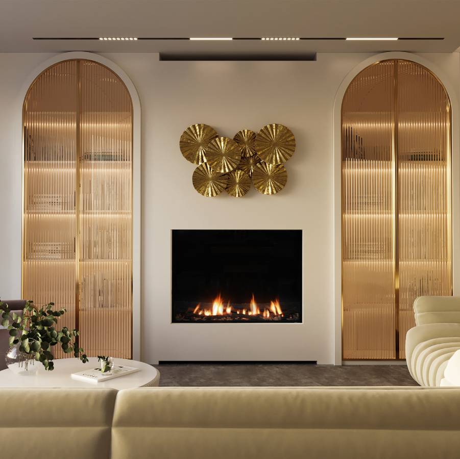 Ortal Front Facing 44HH gas fireplace set into a pale wall between two tall arched fluted-glass cabinets, with a brass sunburst sculpture mounted above and a cream sofa in the foreground