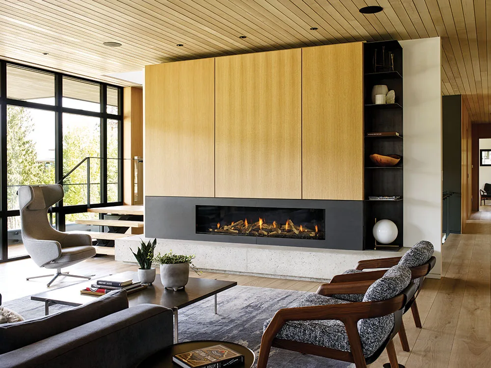 Wide linear gas fireplace with oak paneled wall running directly up to the firebox — finish-to-glass install