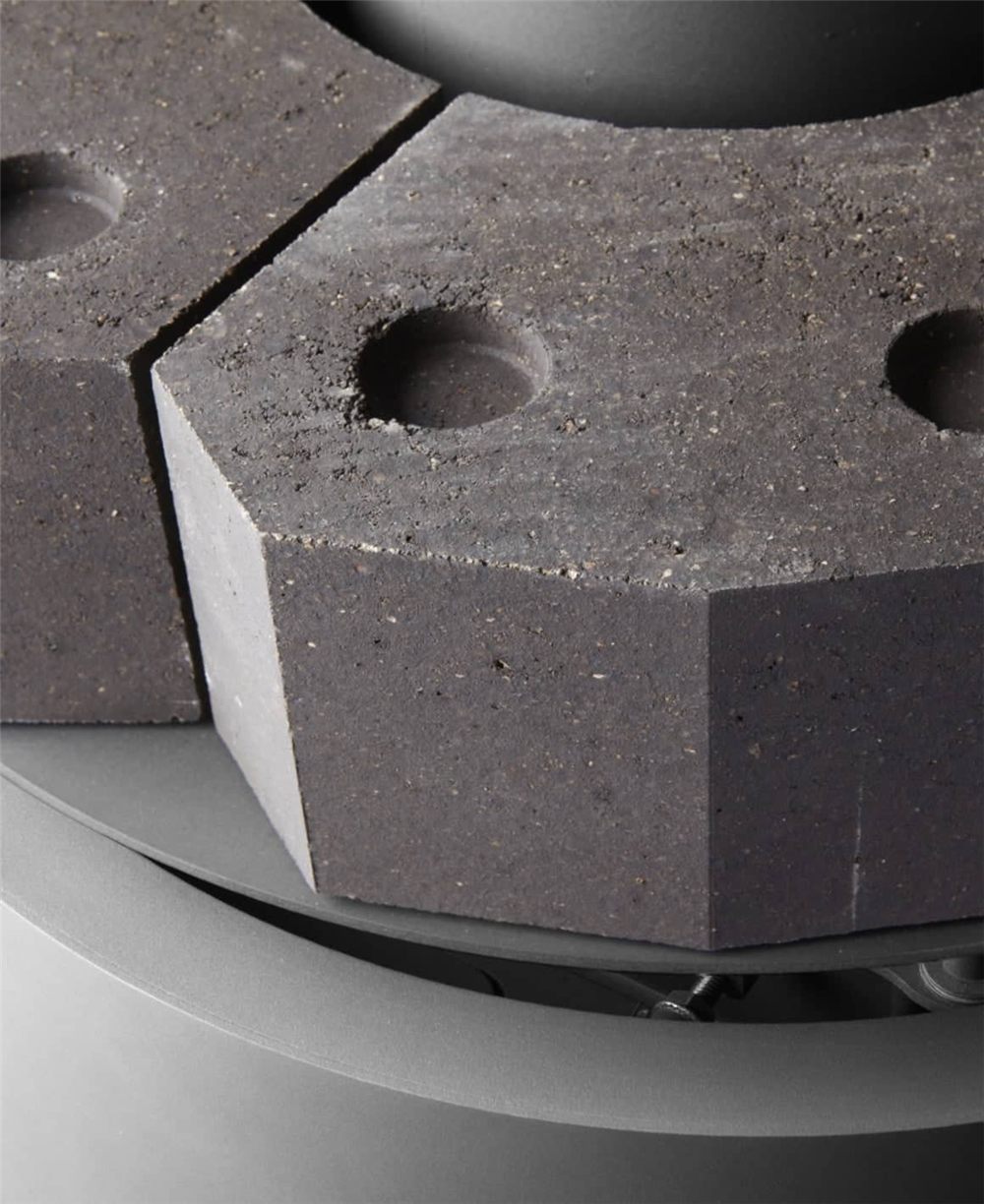 Close view of the heat accumulator of a Stuv 30 Compact H, hexagonal blocks of refractory stone around the base of the stove