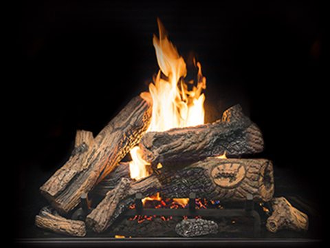 Town & Country Country Home burner: a bed of textured oak logs stacked on a grate with a tall central flame and glowing embers beneath