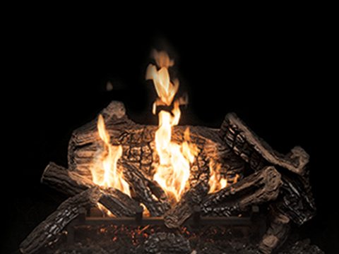 Town & Country Heartwood burner: deeply charred logs with a bright flame rising from their centre