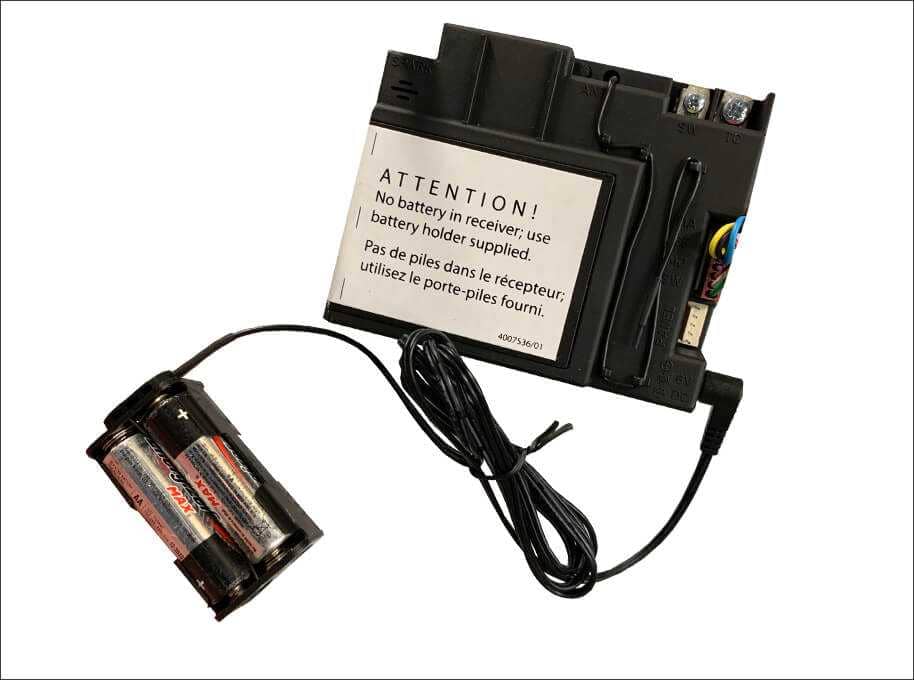 A Valor receiver box with its separate battery holder, loaded with AA batteries, on a short cable
