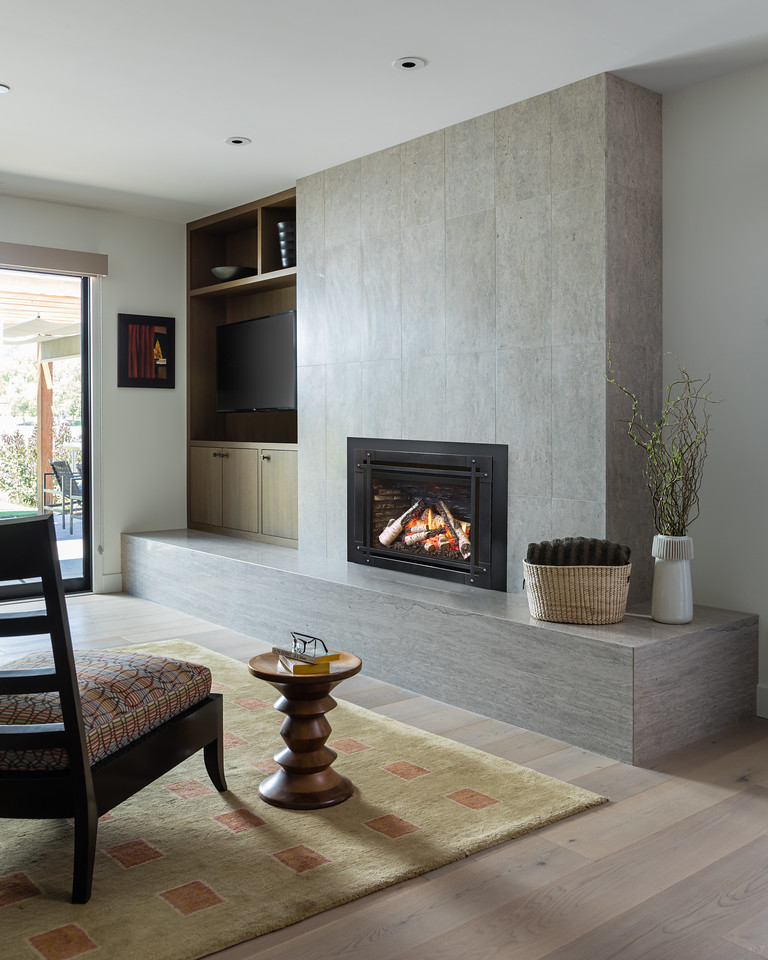 Valor G3.5 700XN gas insert in a contemporary living room with a full-height grey stone tile surround