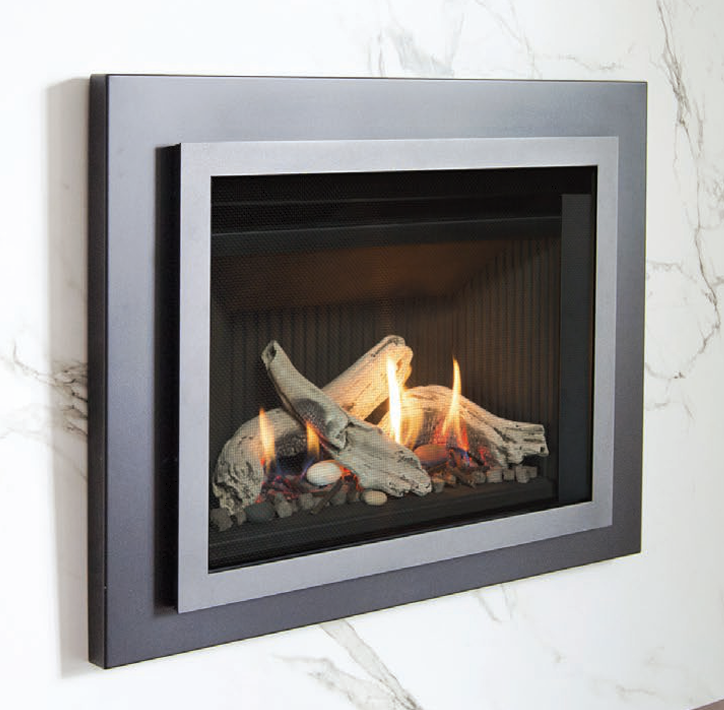 Valor G3.5 700XN gas insert with driftwood log set on white pebble bed and a clean dark trim front against a marble surround