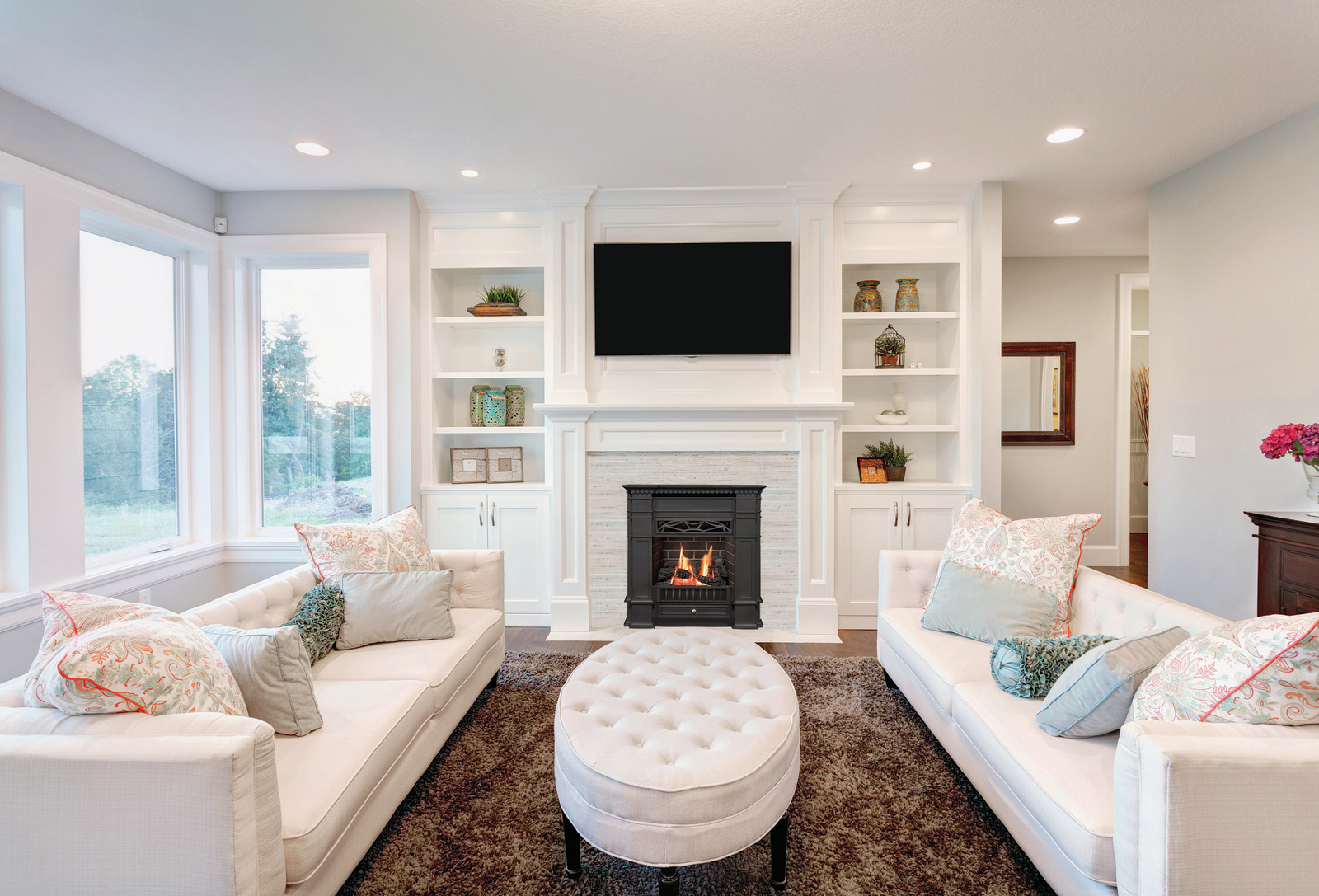 Valor Portrait with a Senator front in a bright living room with white built-in cabinetry and a television mounted above the mantel