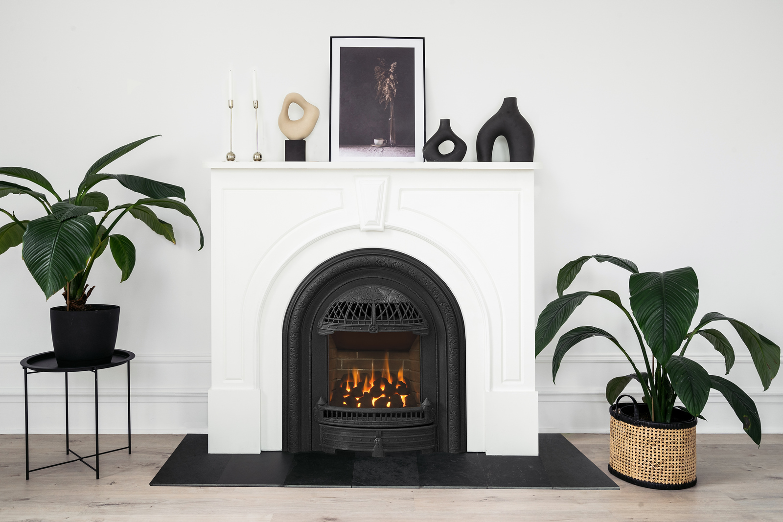 Valor Portrait with a black Windsor Arch cast front in a white arched mantel, styled minimally with plants and candlesticks